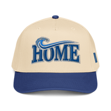 A structured baseball cap with a cream-colored crown and a royal blue visor. The front features an embroidered blue wave graphic above the word 'HOME' in blue varsity-style lettering with a white outline.