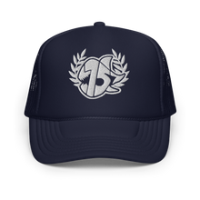 A navy blue FOAM trucker hat with a white embroidered logo on the front, featuring a laurel wreath and SEVEN SHARKS LOGO, set against a plain white background.