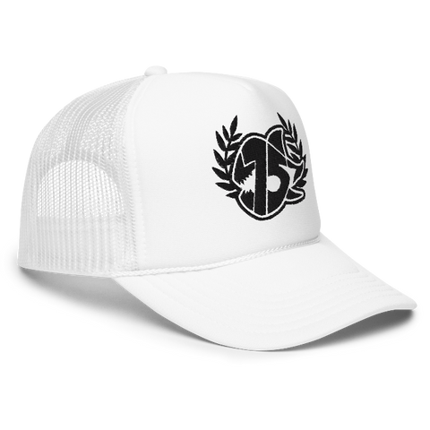 A white trucker hat with white embroidered logo on the front, featuring a laurel wreath and the SEVEN SHARKS logo. The hat has a curved brim and mesh back panels, 